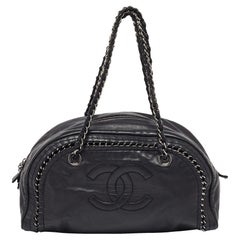 Chanel Bolso bombín Luxe Ligne mediano de piel negra con adornos de cadena
