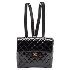 Mochila Chanel con solapa CC de charol acolchado negro