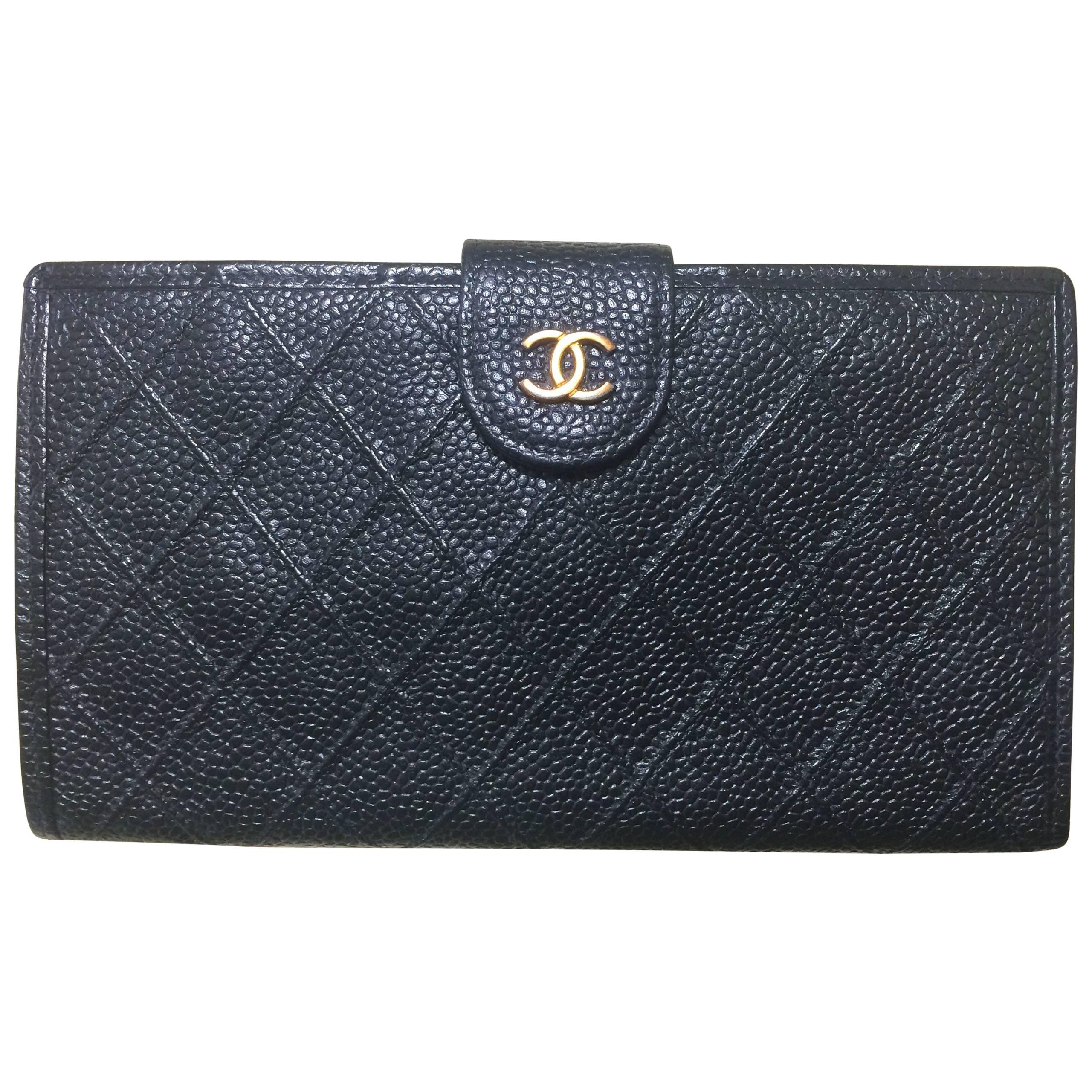 Vintage CHANEL black caviar leather wallet with stitches and gold tone CC motif.