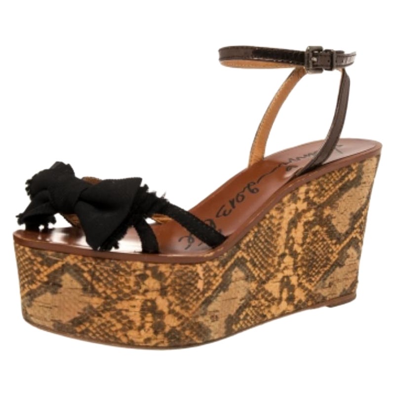 Ces sandales compensées Lanvin sont fabriquées en toile et en cuir. Dotées de talons compensés imprimés python, d'un nœud sur les orteils et d'une fermeture à boucle au niveau des chevilles, ces sandales sont faciles à porter et peuvent être