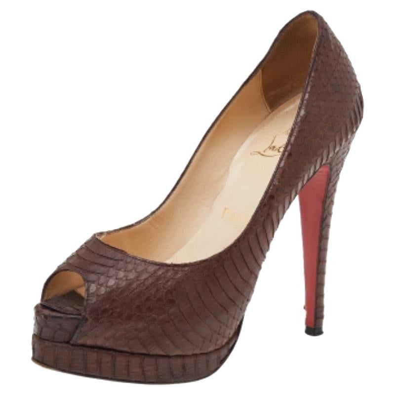 Estos zapatos de Christian Louboutin, impecablemente esculpidos en una forma llamativa, añaden al instante un toque definitorio a tus pies. Están confeccionados en piel marrón con relieve de pitón y vienen con peep-toes, plataformas y tacones