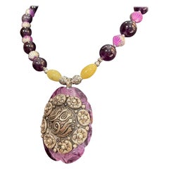 LB propose un collier broche florale vintage en argent sterling avec boucle en bakélite et verre améthyste