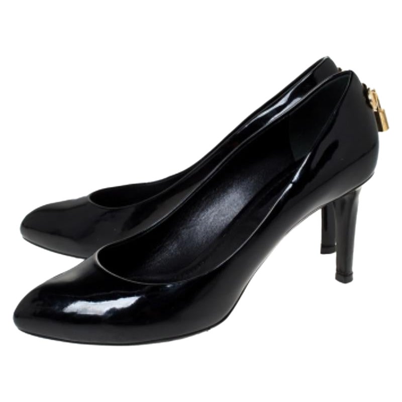 Qué espléndidos y gloriosos son estos zapatos de salón Oh Really! de Louis Vuitton! En un precioso color negro, están confeccionados en charol y tienen puntera afilada. Lucen un artístico detalle de candado dorado grabado en los contrafuertes del