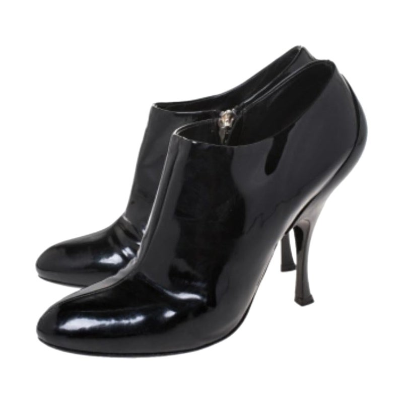 These Miu Miu ankle booties are timeless and sophisticated. Crafted from glossy patent leather, they carry a classic shade of black. They are styled with round toes, silver-tone hardware, zip closures and 14 cm high heels. They are finished with