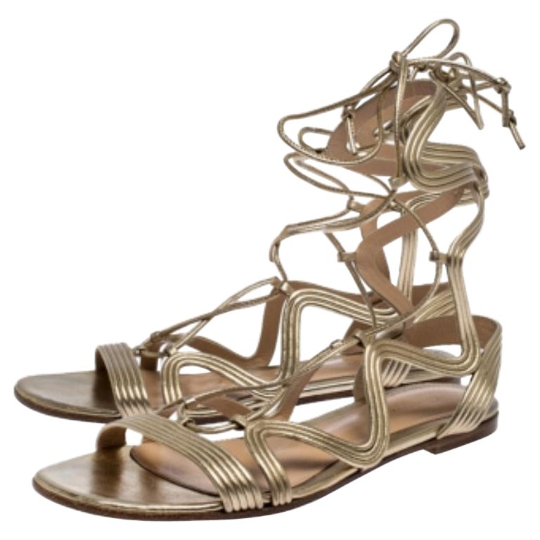 Die Ledersandalen von Gianvito Rossi sind ebenso elegant wie robust. Das aus goldfarbenem Metallic-Leder gefertigte Modell ist mit Cutouts und Knöchelriemen versehen. Perfekt zur Kombination mit Sommerkleidern, von der Verabredung zum Mittagessen