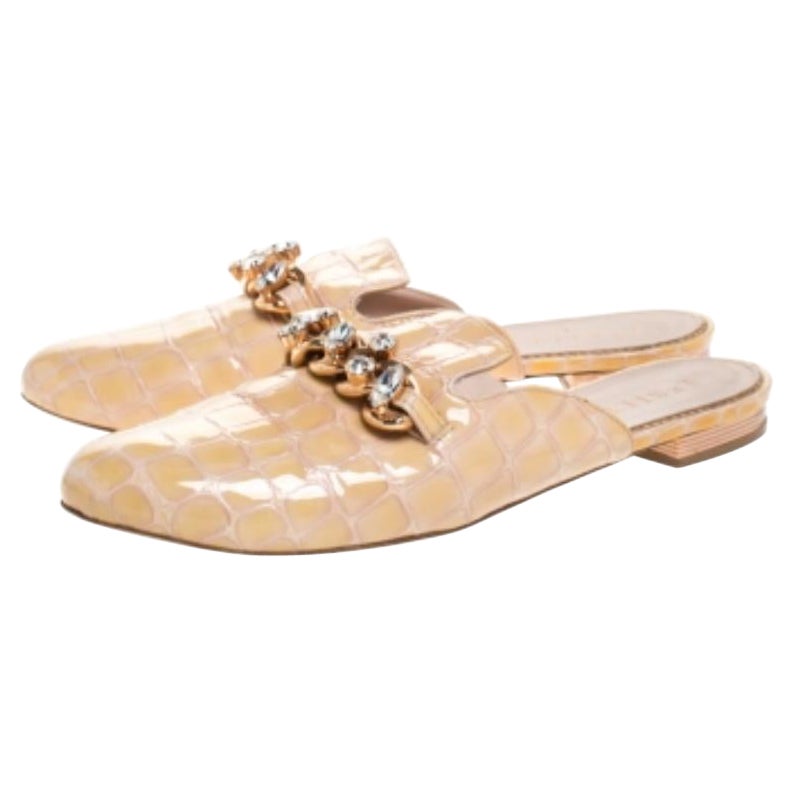 Dai il meglio di te quando esci con queste mules piatte. Realizzate in pelle verniciata color crema con effetto coccodrillo, sono impreziosite da catene con cristalli sulla tomaia. Queste ballerine di design di Le Silla sono un must del tuo