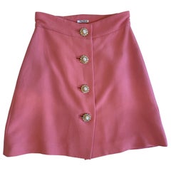 Miu Miu pink mini skirt with flower-shaped buttons.