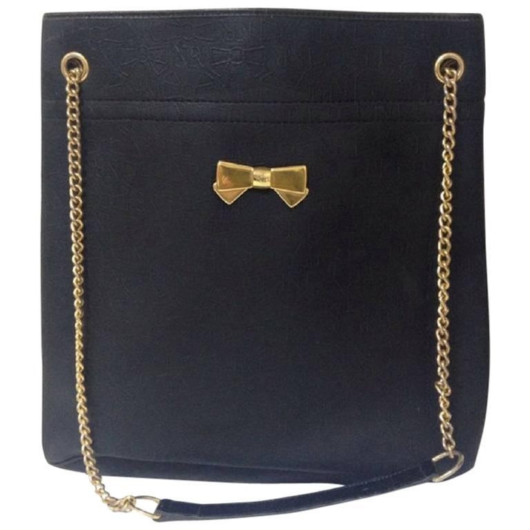 Vintage Nina Ricci black tote bag with golden chain straps with golden logo bow. For Sale