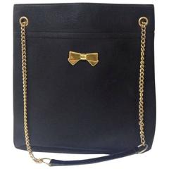 Vintage Nina Ricci black tote bag with golden chain straps with golden logo bow.