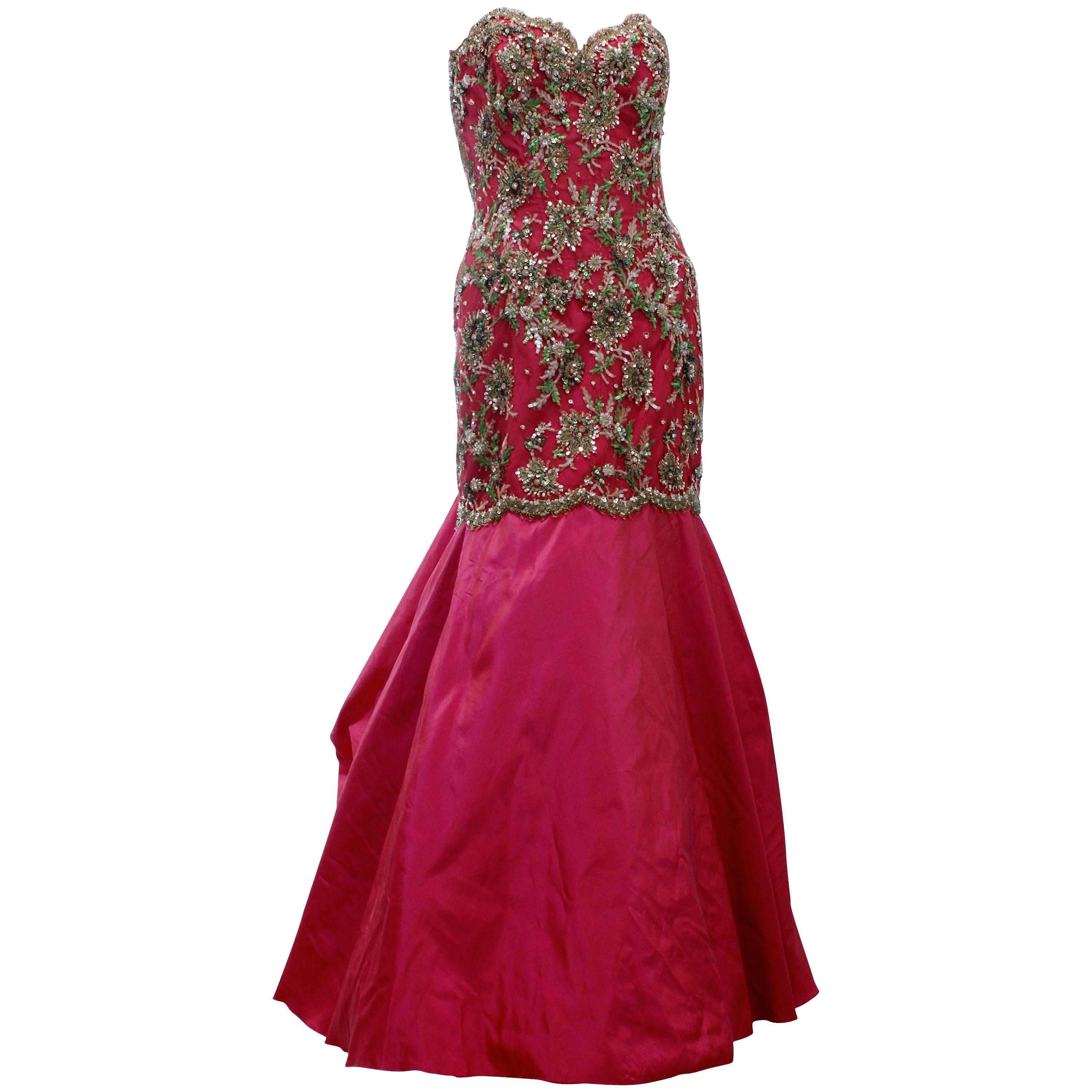 This unique sleeveless evening gown was designed by Vicky Tiel Couture, likely in the 1990s.  Made from a rose pink silk blend taffeta, it features a trumpet or mermaid silhouette and an intricately beaded and sequined bodice.  Fully-lined with
