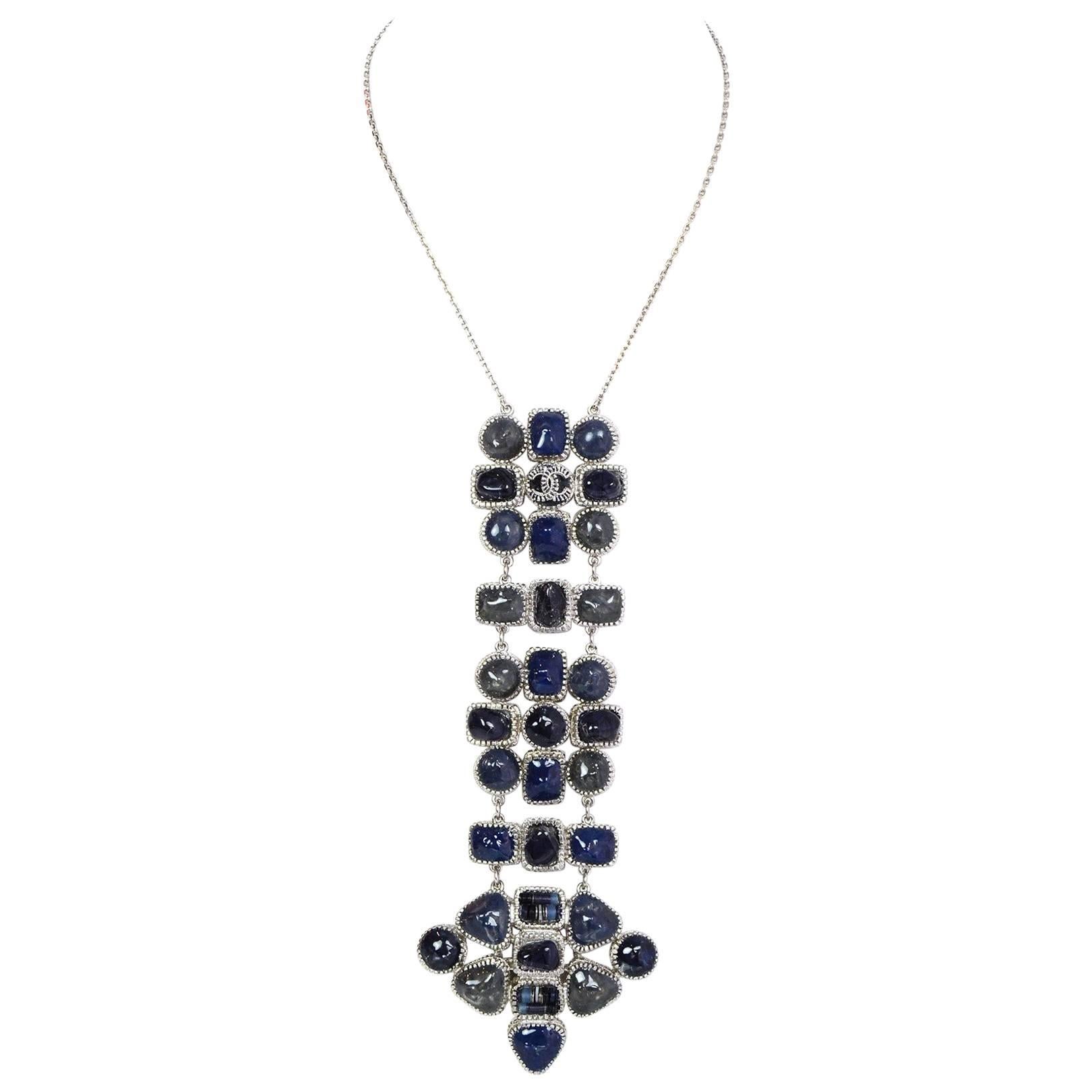 Chanel Blue Stone Long Pendant Necklace
Features pin back closure on back of pendant to keep necklace in place

Made In: France
Year of Production: 2014
Color: Silvertone and different shades of blue
Materials: Metal and stone/glass
Closure/Opening: