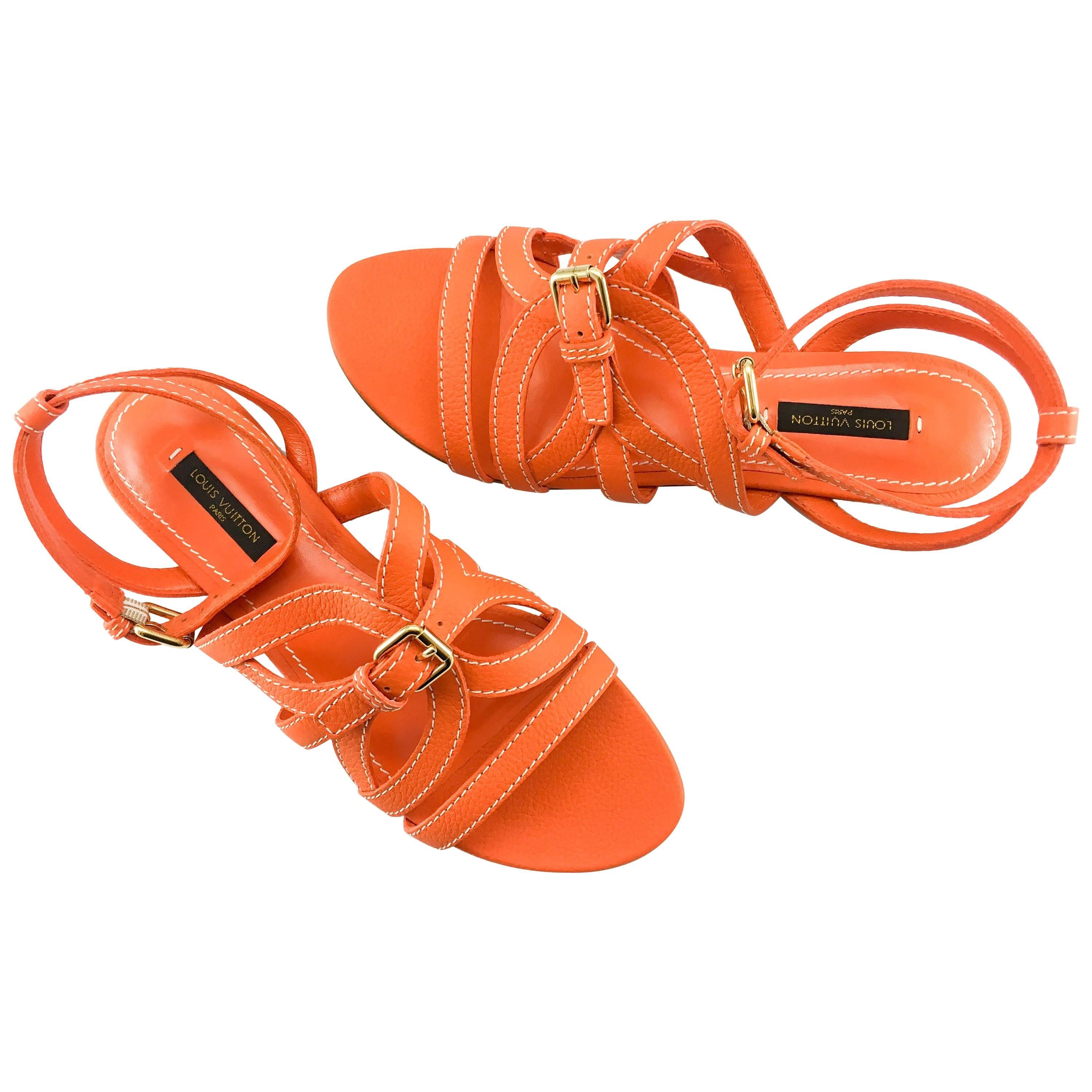 These really cool Louis Vuitton sandals are in unworn condition. Made in orange leather, these flat, strappy sandals feature one buckle on the ankle and one on the front. Really stylish, they are certain to steal the attention in the hot months of