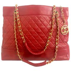 Vintage CHANEL red lambskin large tote bag with gold tone chains and CC charm.