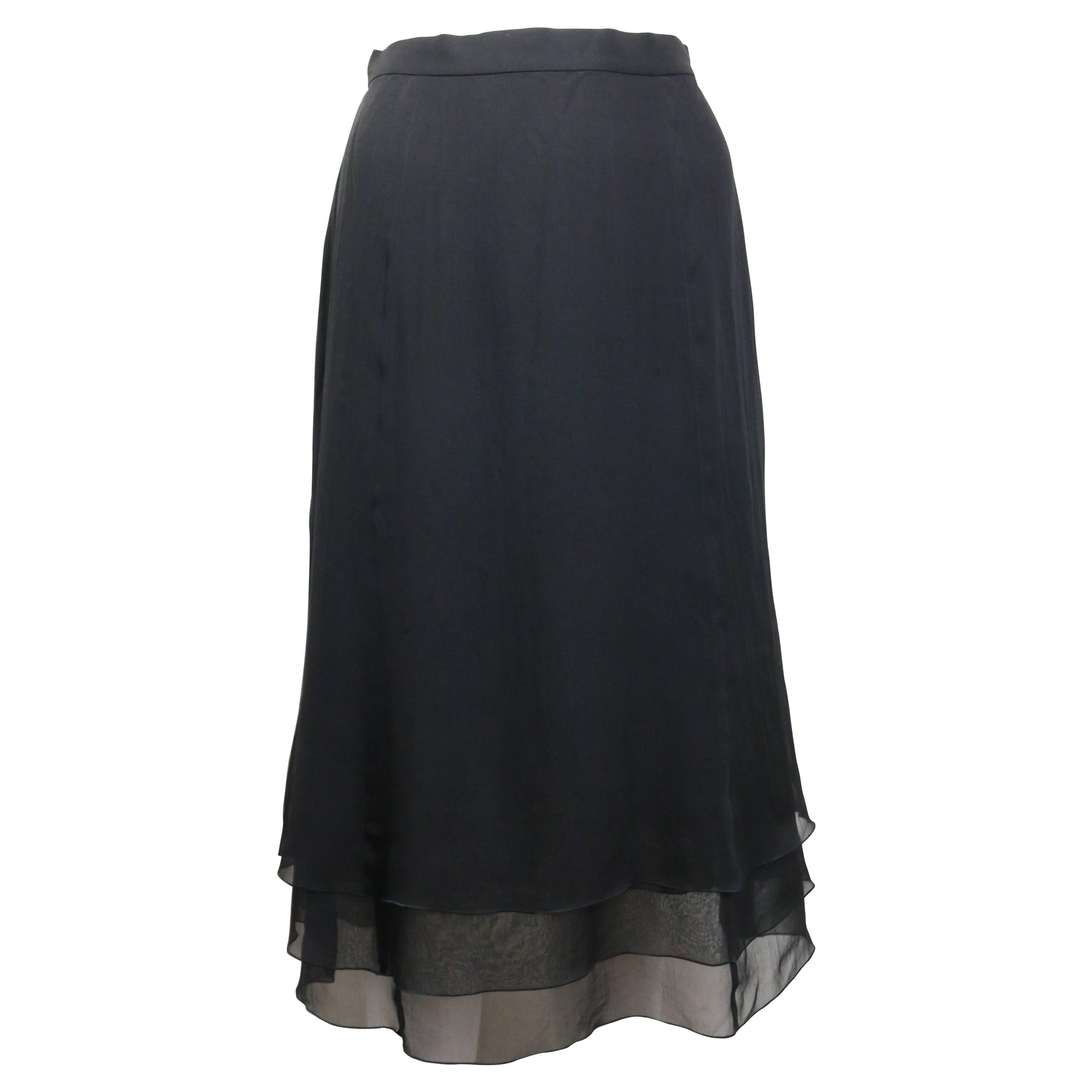 - Vintage Chanel black silk knee length skirt from year 1995A. Featuring three layers with ruffle hem. One gold 