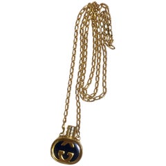 Vintage Gucci gold and navy round shape perfume bottle necklace with iconic logo