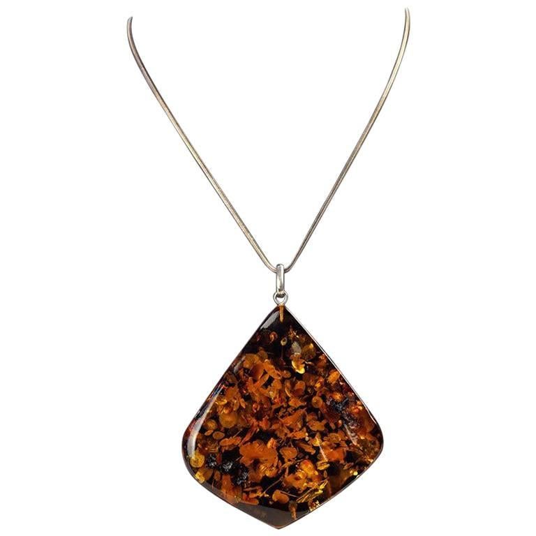 Vintage sterling silver necklace with an oversized triangular shaped Amber stone, circa 1970.
*AMBER APPEARS DARKER IN DISPLAY PHOTO #1  AMBER IS CLOSEST IN COLOR TO PHOTO #3*

Measurements: 
About 11.5 inches long when clasped
Amber Stone: 2.5