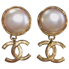 Vintage CHANEL classic round white faux pearl and golden CC dangling earrings.