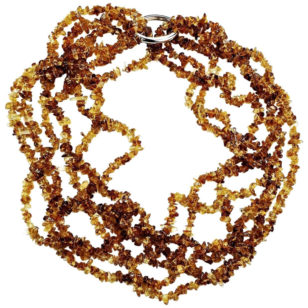 Three 36 inch; strands of honey colored tumbled citrine chips with a gold tone clasp. 
You can wear these long and swinging or tie a knot in them. You can double and twist and clasp to make a six-strand choker. However, you wish to wear them, these