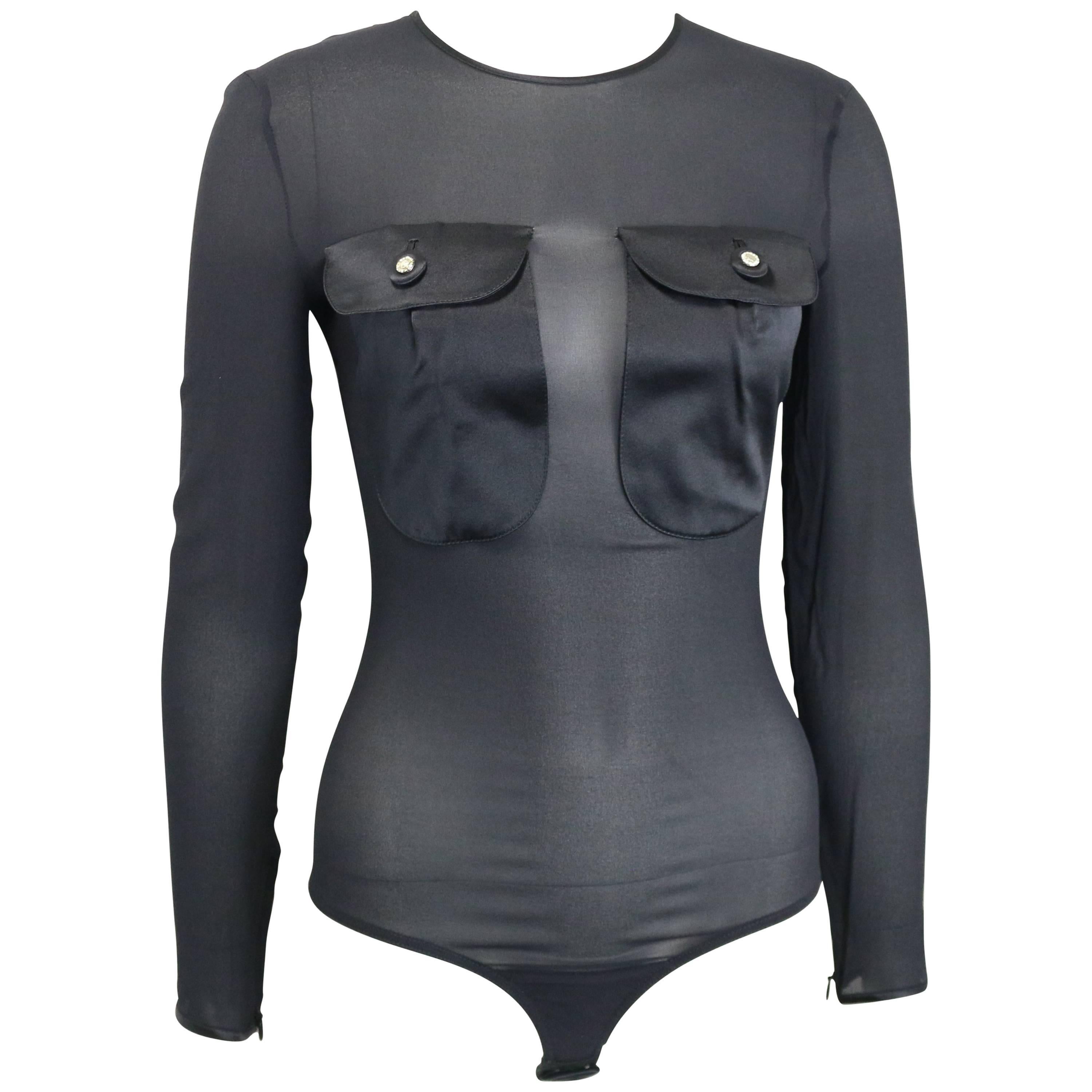 - Gianni Versace Couture, top in seta nera trasparente della collezione 1996. Nuovo di zecca con etichetta. 

- Due tasche anteriori con patta in raso con Medusa di strass. 

- Rivestimento in raso.

- Chiusura con zip sul retro. 

- Chiusura con