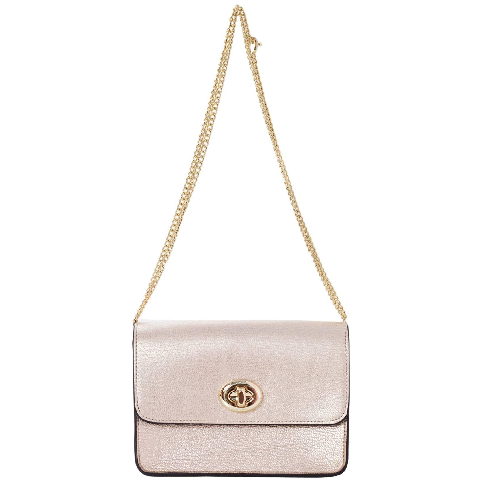 Coach Light Pink Metallic Mini Twist Lock Crossbody NWT

Color: Light pink
Hardware: Goldtone
Materials: Leather, metal
Lining: Brown suede
Closure/Opening: Flap top with twist lock
Exterior Pockets: One at back
Interior Pockets: One zip