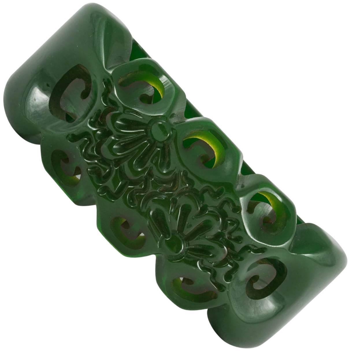 A carved green bakelite clamper bracelet, with stylised floral motif, USA, 1930s For Sale