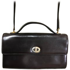 Retro Christian Dior dark brown leather shoulder bag with CD motif and strap.