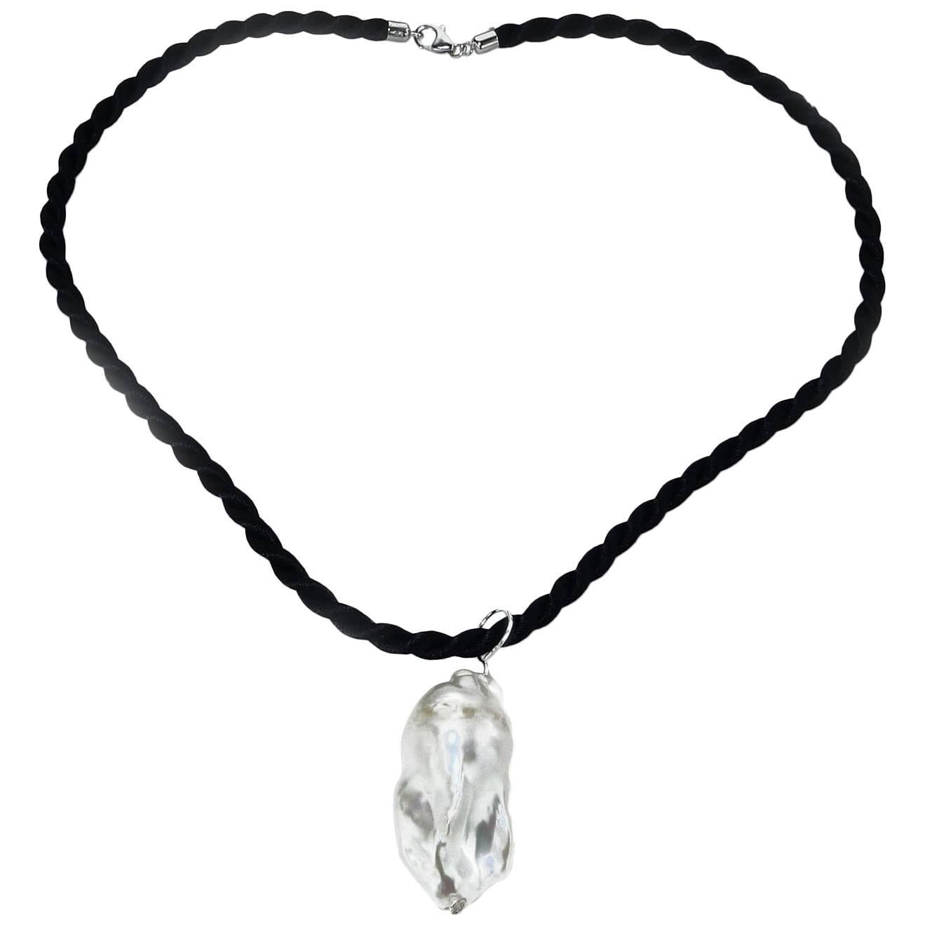 Magnificent one of a kind White Baroque Pearl Pendant on a black cord. The pearl is beautiful from all angles. This can be worn on the cord or a silver choker or other device. The black cord is 16.25 inches and closes with a lobster claw clasp. The