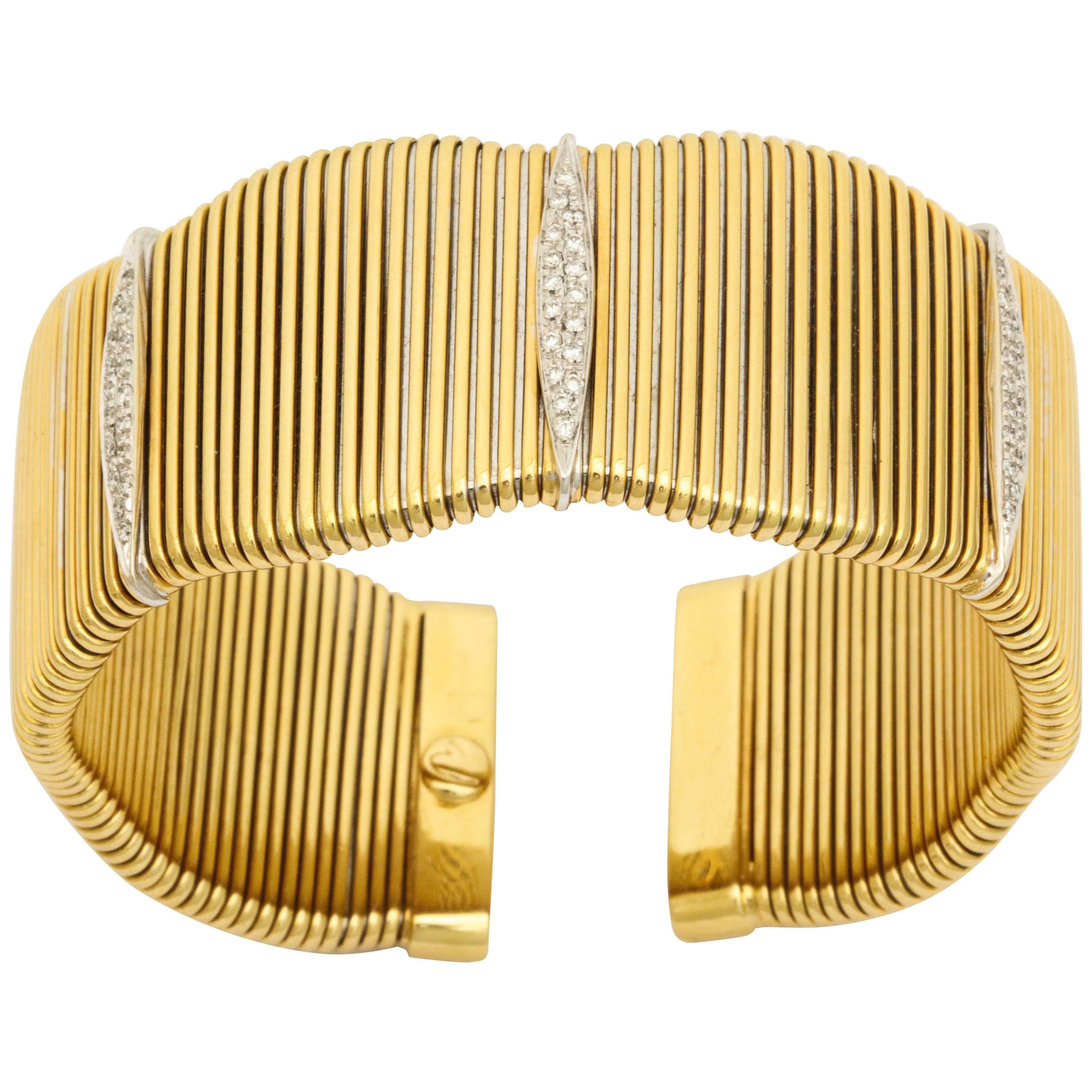 A wonderful modernist French gold cuff. A flexible body in 18kt gold with white gold and diamond cameos. 