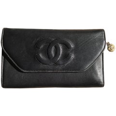 Vintage CHANEL black leather wallet with large CC stitch mark. 