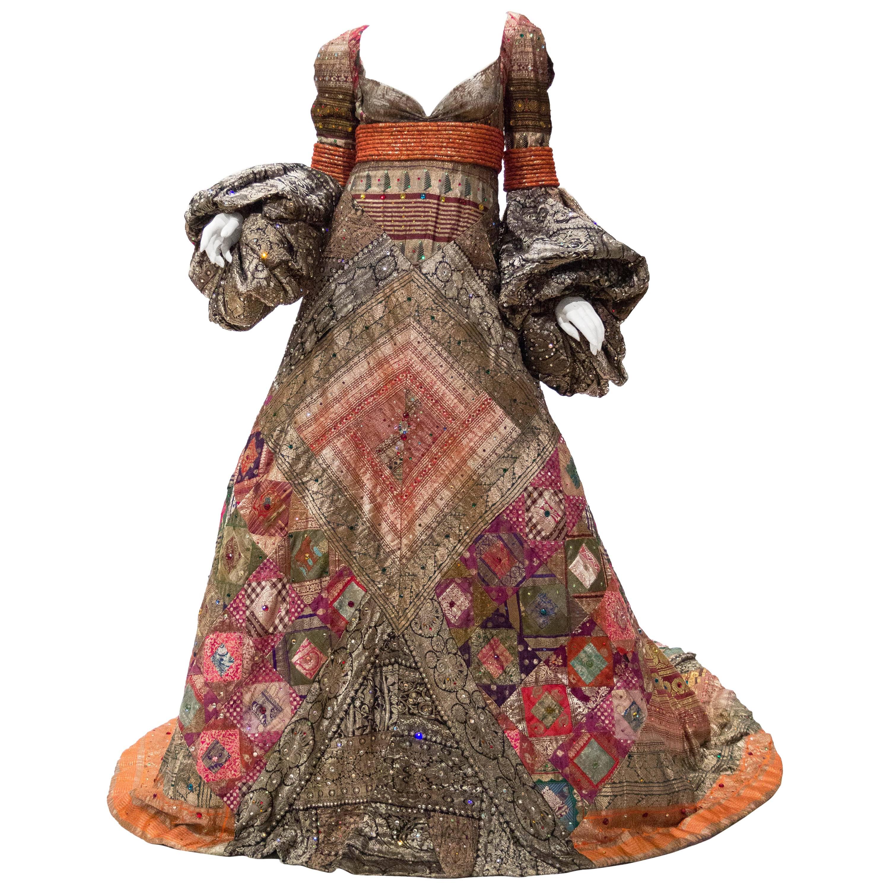 Cette robe est fabriquée à partir d'anciennes bordures de sari indien, assemblées en un patchwork magistral évoquant les quilts américains. Cette pièce était le dernier look nuptial du défilé et a été présentée avec les seins exposés, très français.