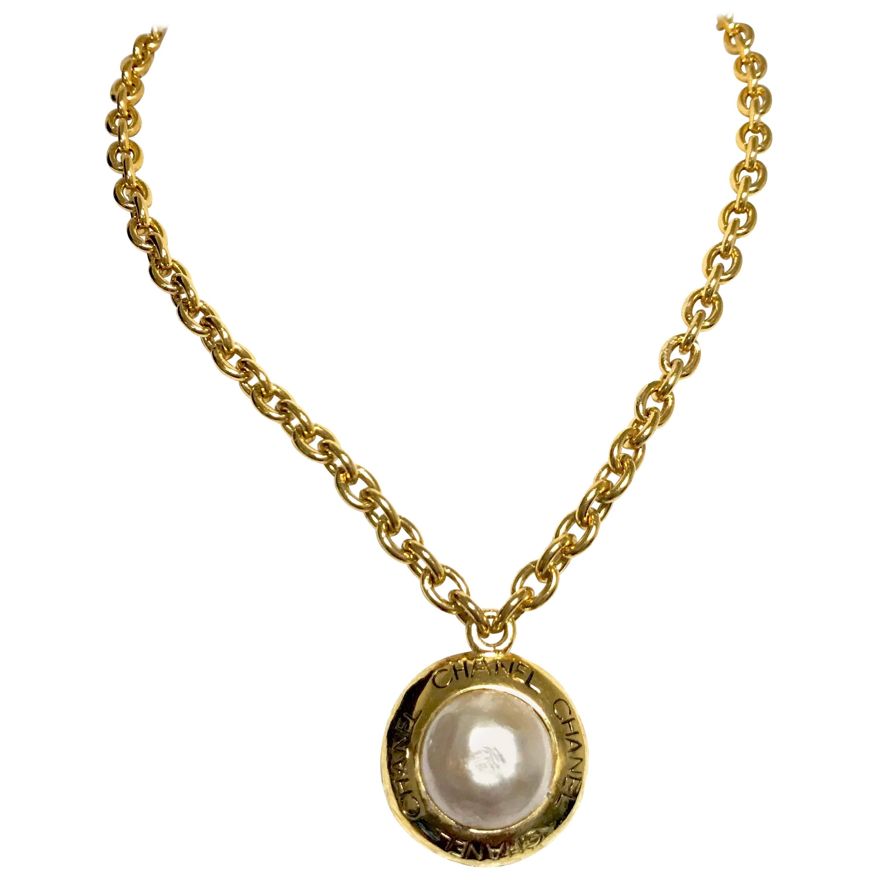 Vintage CHANEL golden chain necklace with round faux pearl and logo pendant top. For Sale