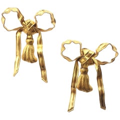 Très grandes boucles d'oreilles « nœud » articulées en métal doré, Yves Saint Laurent, Paris, années 1980