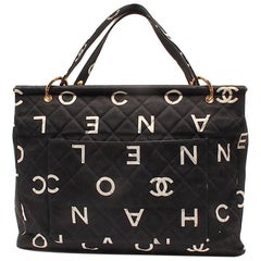 Vintage CHANEL black fabric canvas large tote bag with white Chanel CC prints.