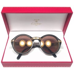 Lunettes de soleil Cartier Cabriolet rondes noires et dorées 49MM en or 18 carats, France, années 1990