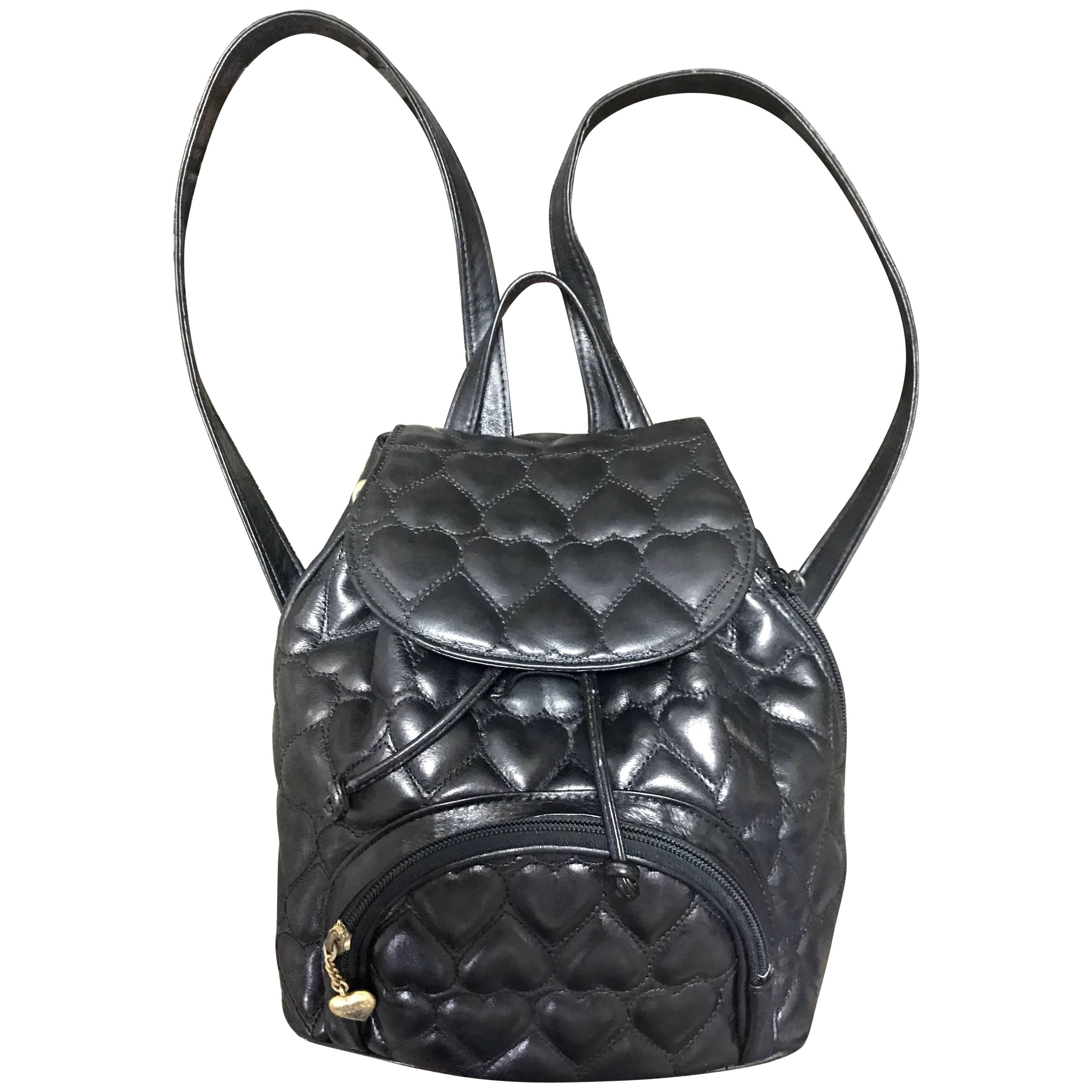 Vintage MOSCHINO black heart quilted leather backpack with golden heart motif.