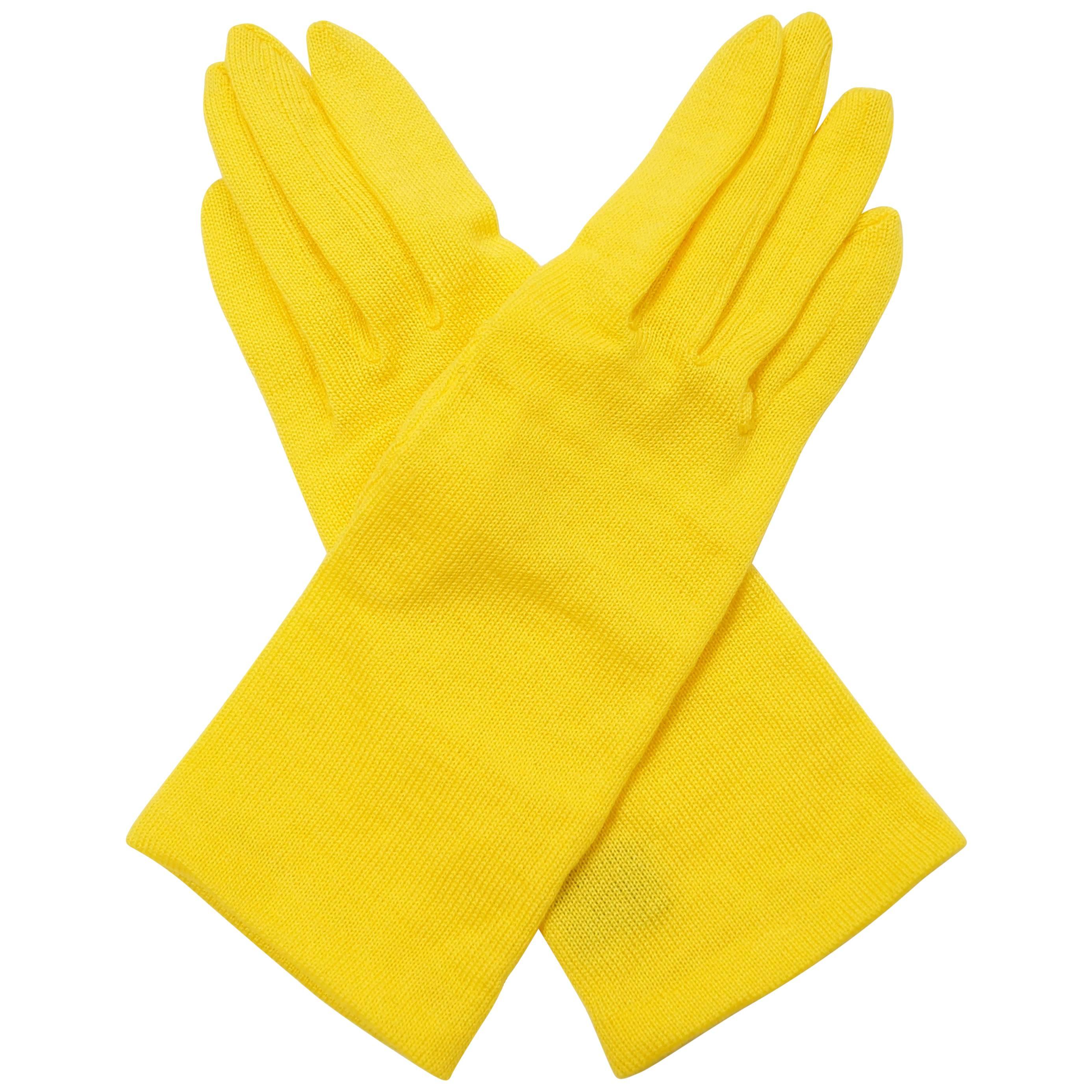 Dramatic canary yellow knit wool blend gloves by Yohji Yamamoro. Gloves reach above the wrist, are soft and loosely knit, with rounded fingertips. Seams at sides and thumb. Medium.