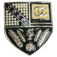 CHANEL Escutcheon Brooch in Pale Gilded Metal, Pearls and Colored Resin