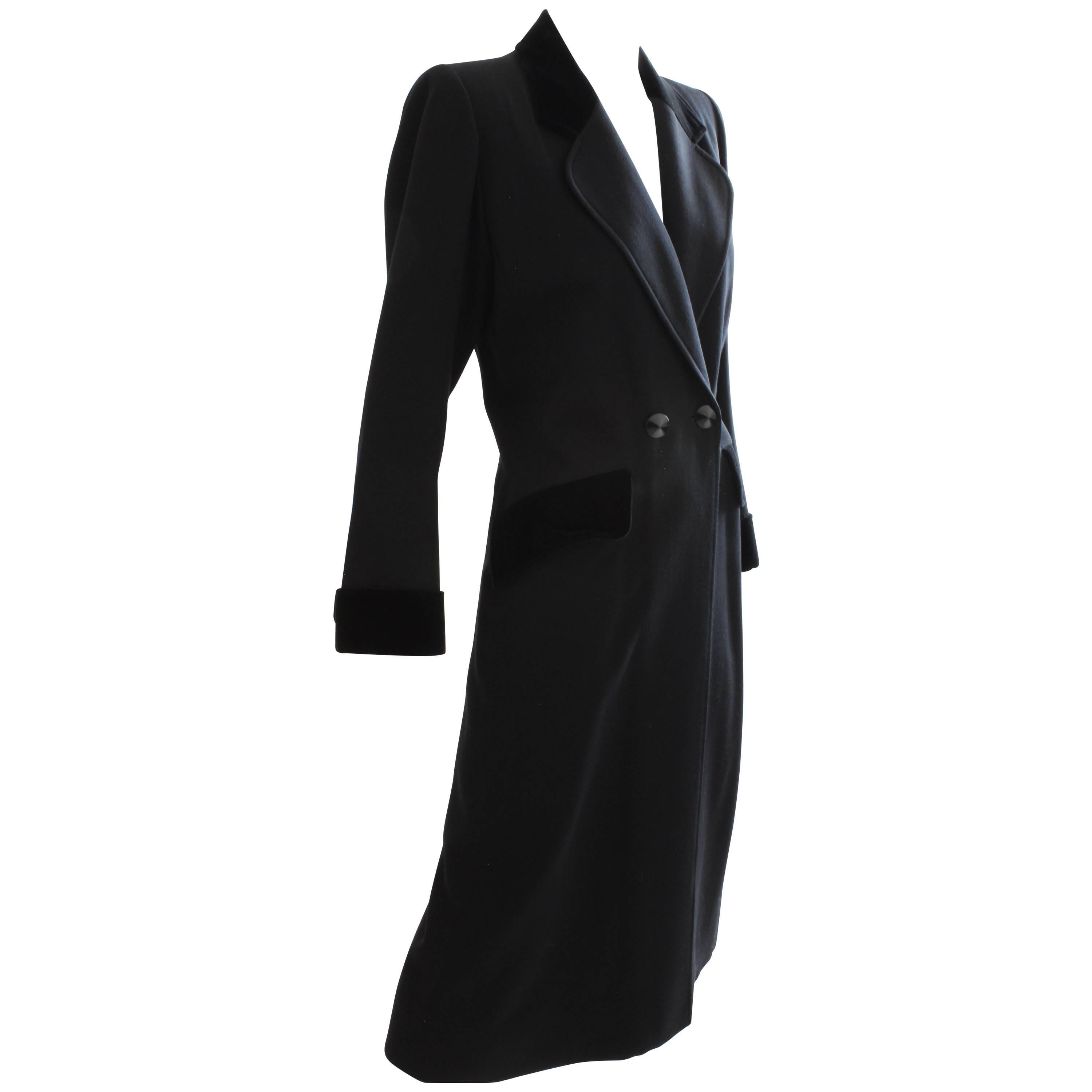 This fabulous black coat was made by Yves Saint Laurent, most likely in the late 1970s.  Made from a black wool gabardine fabric, it features black velvet trim at the collar, pocket flaps and cuffs, and black faceted buttons.  Fully-lined and in