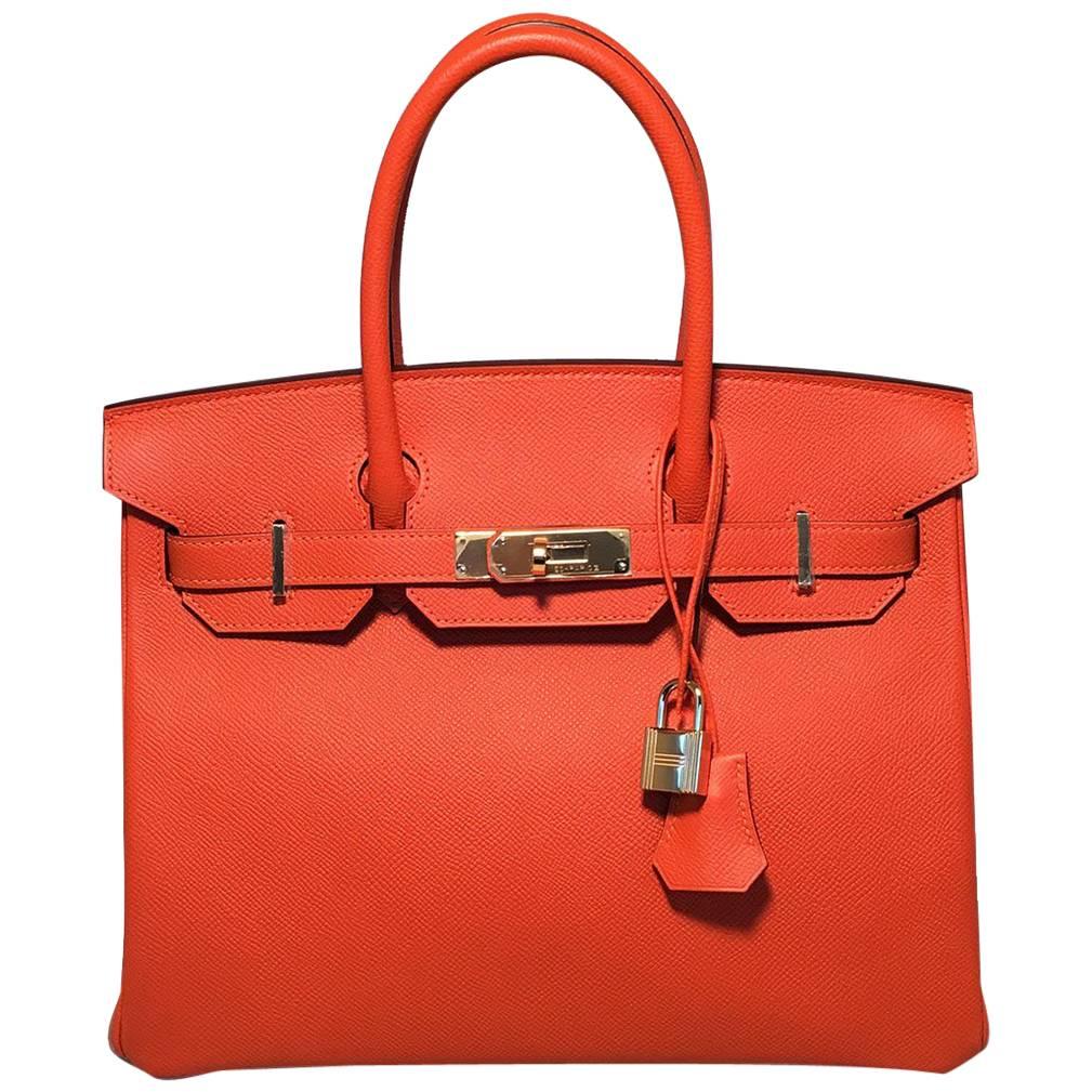GORGEOUS Hermes orange veau grain lissse birkin bag in excellent condition.  Orange veau grain lisse leather with gold palladium hardware. Signature double strap twist top lock opens to a matching orange kidskin lined interior that holds 2 slit and