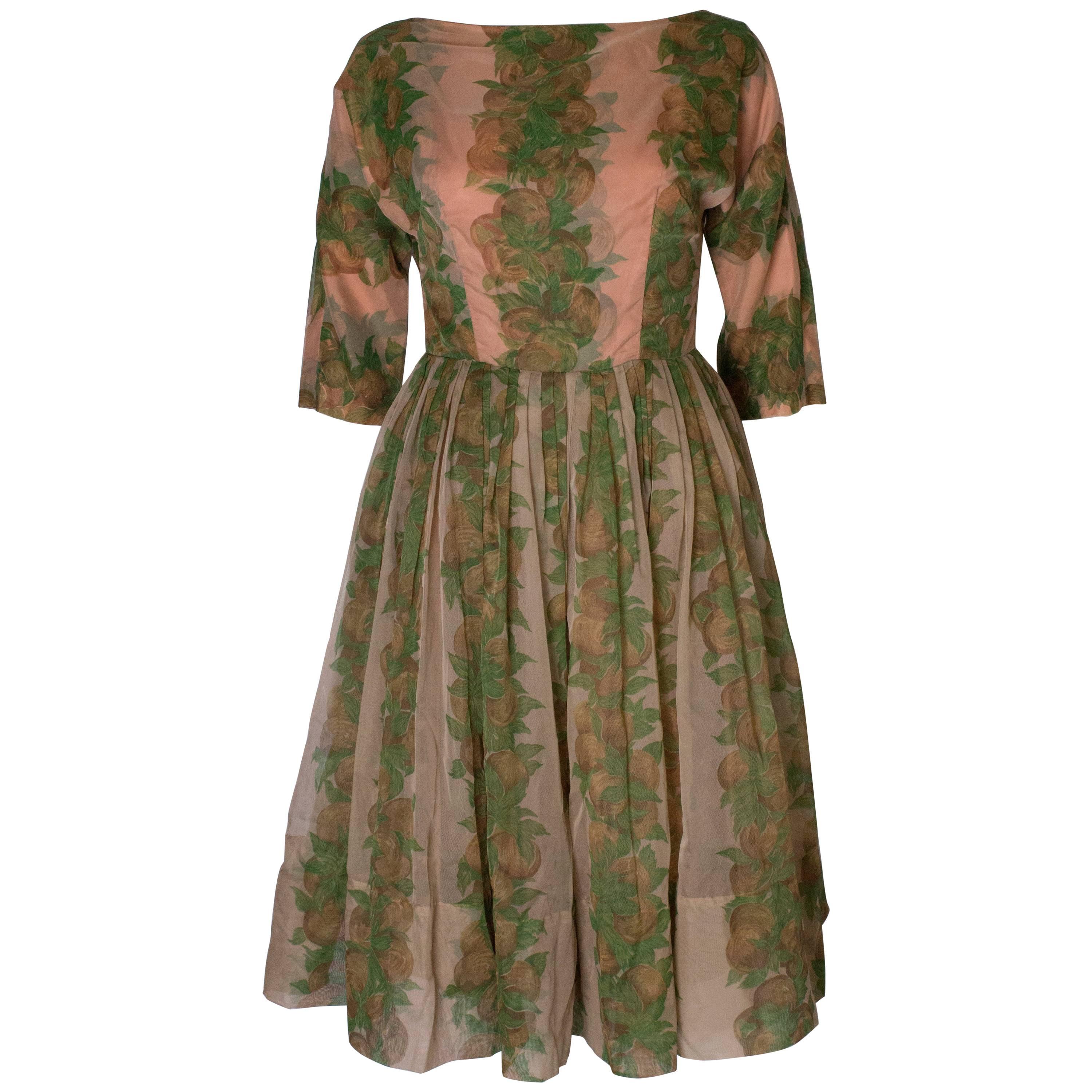 A Vintage 1950s Apricot, Green and Brown print swing cinch party dress