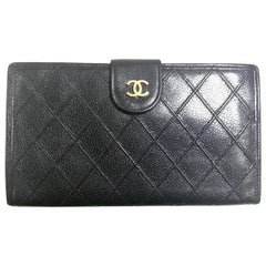 Vintage CHANEL black caviar leather wallet with stitches and gold tone CC motif.