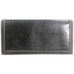 Retro Valentino black leather long wallet with beige stitches and V logo.