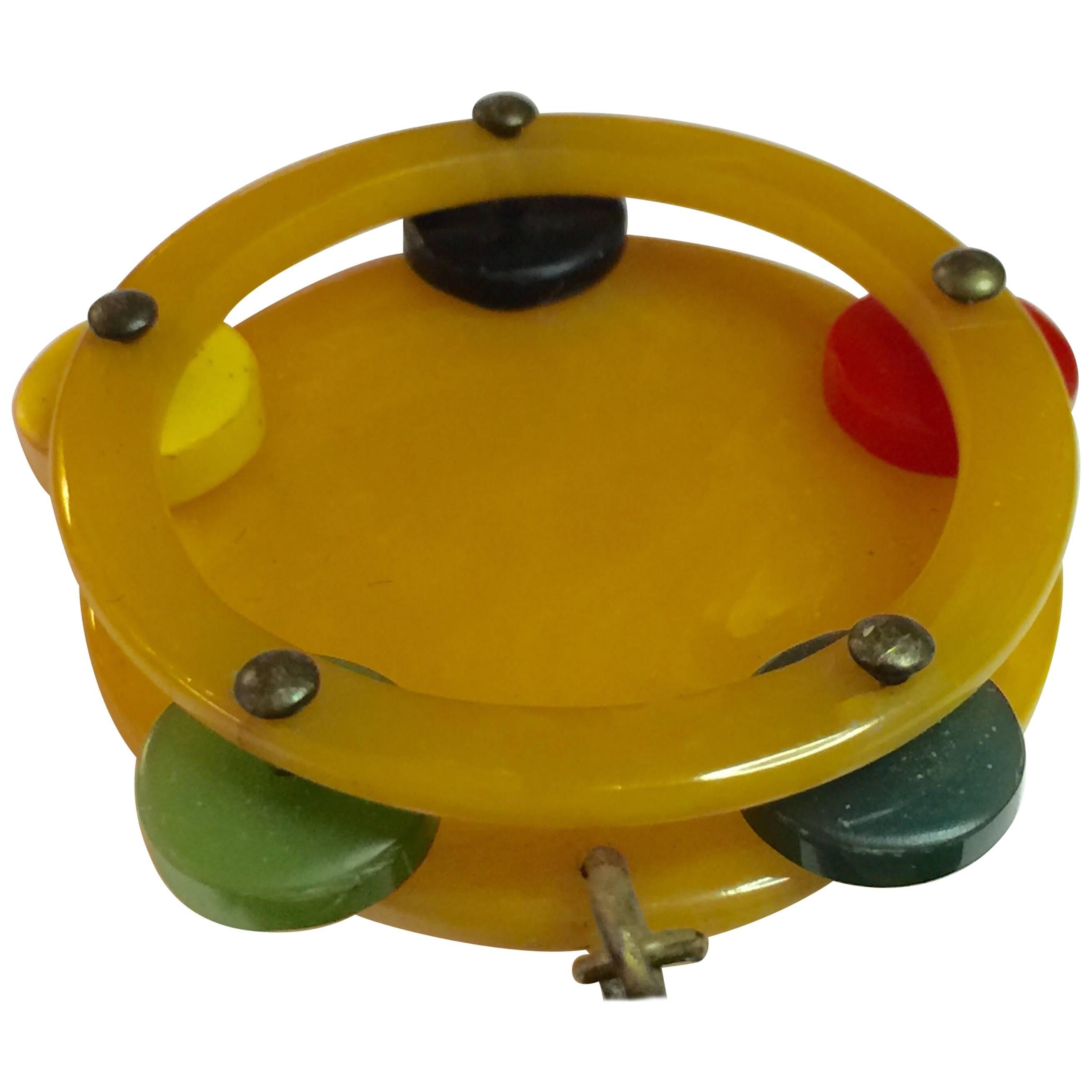 Always adorable are figural bakelite pins, and this 1930s Multicolored Bakelite Figural Tambourine Dangling from Bar Brooch Pin is no exception. An extremely rare pin, this dangling from a bar pin version is probably almost one of a kind. The