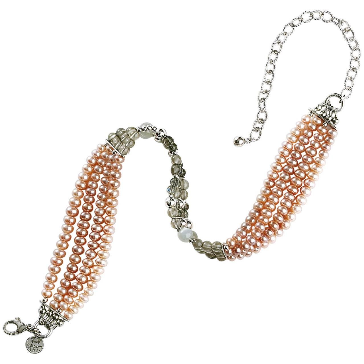 The choker is made up of peach cultured freshwater pearls, gray moonstone and labradorite beads with silver, barely visible near the stones. Elevating the necklace is a silver lobster lock and fancy extension chain 3 inches in length for easy