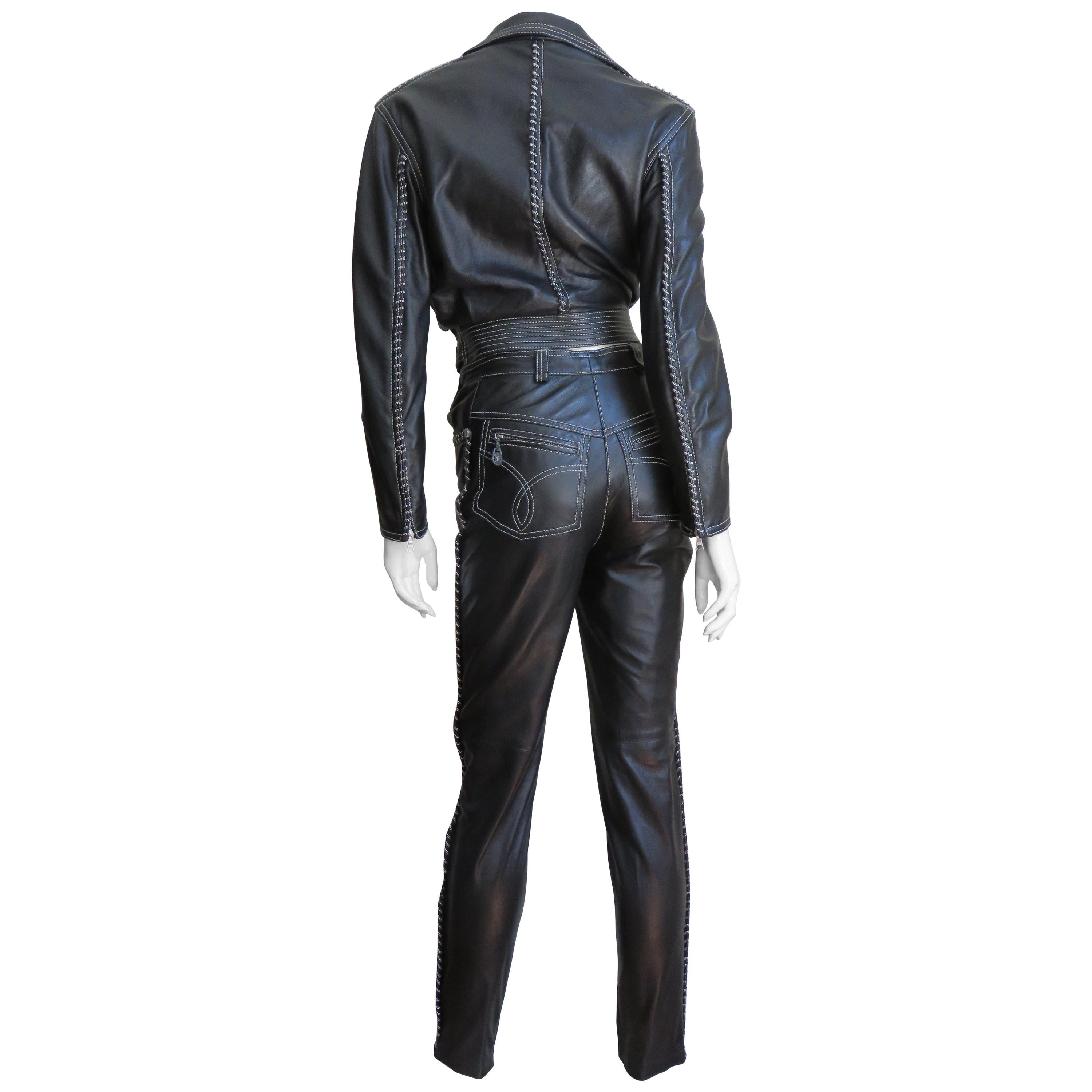 A fabulous 2 piece supple black leather motorcycle jacket and pant set from Gianni Versace's A/W 1992 Collection. The jacket is motorcycle style with a lapel collar, zipper front closure, 3 zipper welt pockets, zipper wrists and an adjustable belt