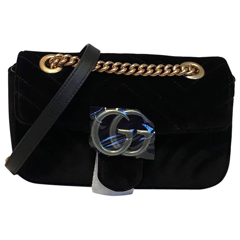 NWOT Gucci GG Marmont Mini Black Velvet Shoulder Bag in excellent like-new condition.  Black velvet quilted exterior trimmed with bronze hardware and matching blue leather. Front GG Gucci logo latch closure opens via single flap to a pink silk lined