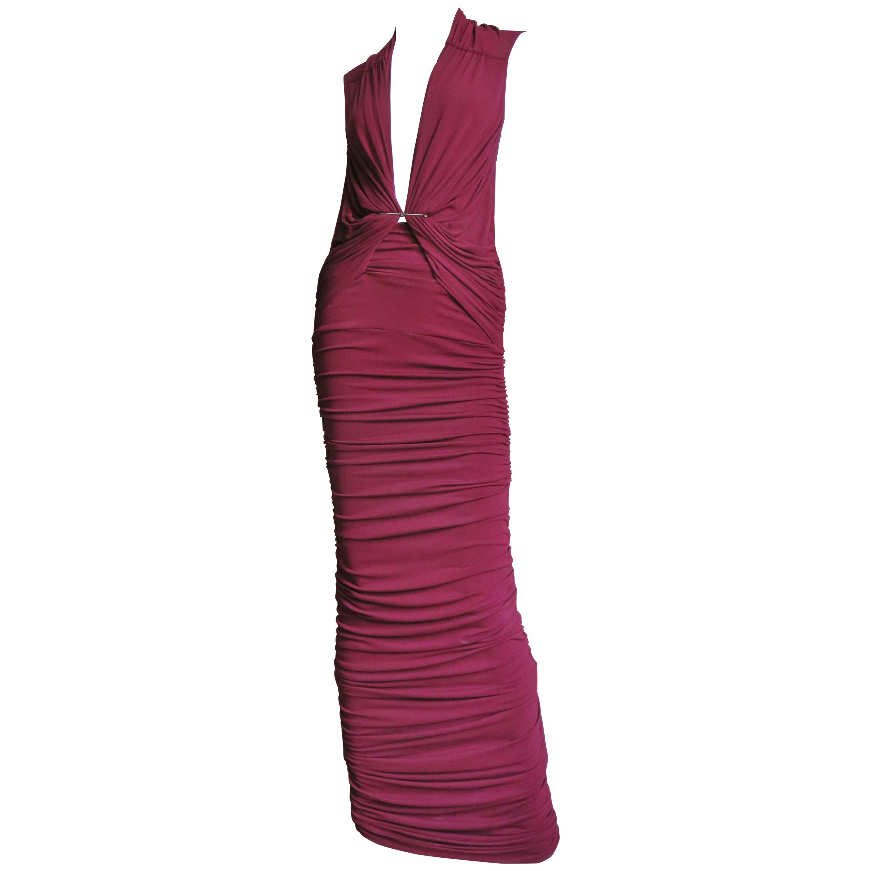 A gorgeous burgundy fine silk jersey gown from Lanvin.  It has a plunging neckline, exposed side bodice and fabulous ruching all meeting held together with large a horizontal saety pin.  The dress has horizontal ruched across the the entire length