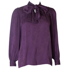 A Vintage 1970s silk purple pussy bow blouse by Yves Saint Laurent
