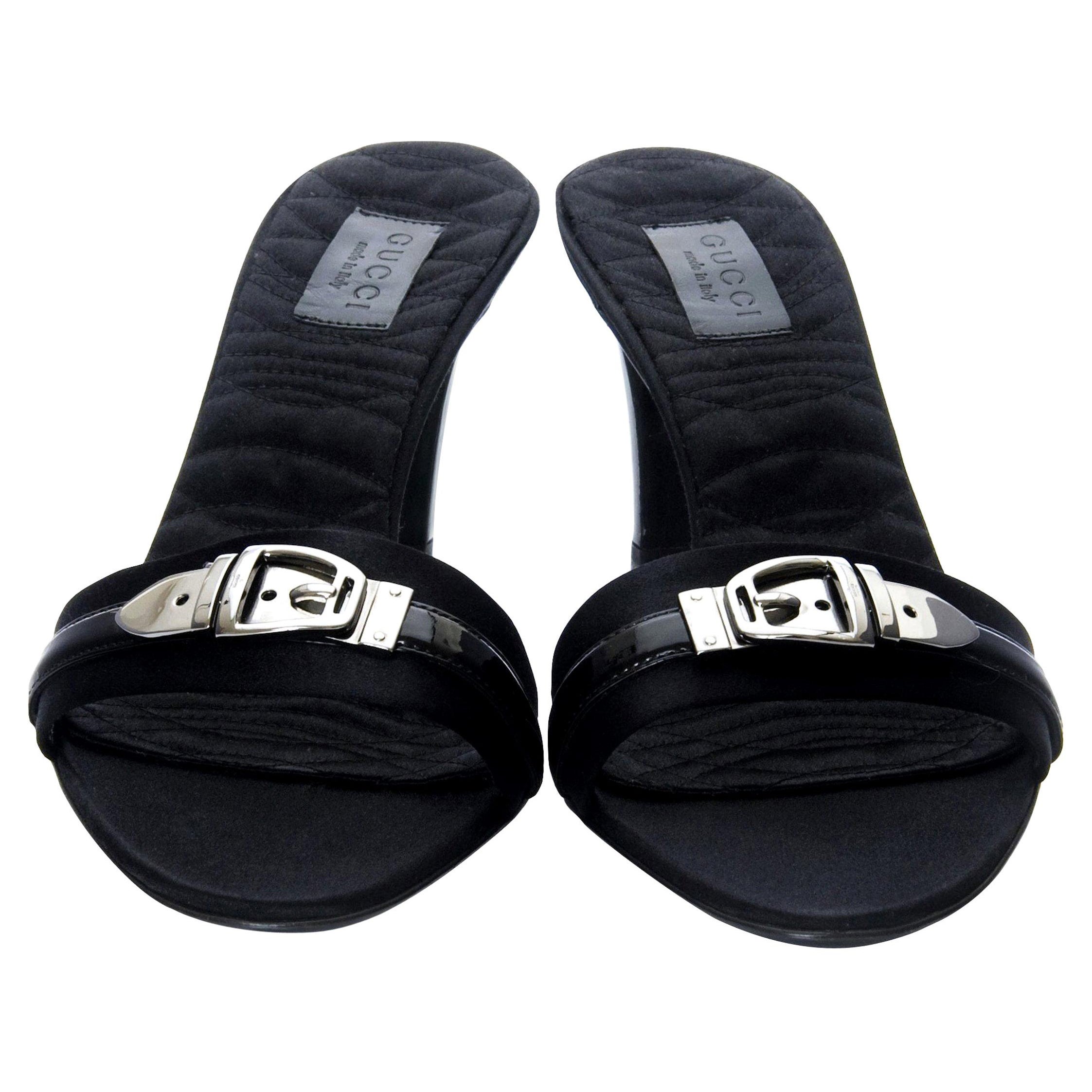 Mules Gucci
Tout neuf
* La beauté du satin noir
* Accents en cuir verni
Semelle intérieure matelassée et rembourrée
*Boucle en bronze
* Talon noir verni
* Talon de 3,5 pouces
* Avec boîte 
