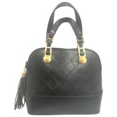 Gianni Versace Vintage black bolide shape bag with a tassel and sunburst motifs 